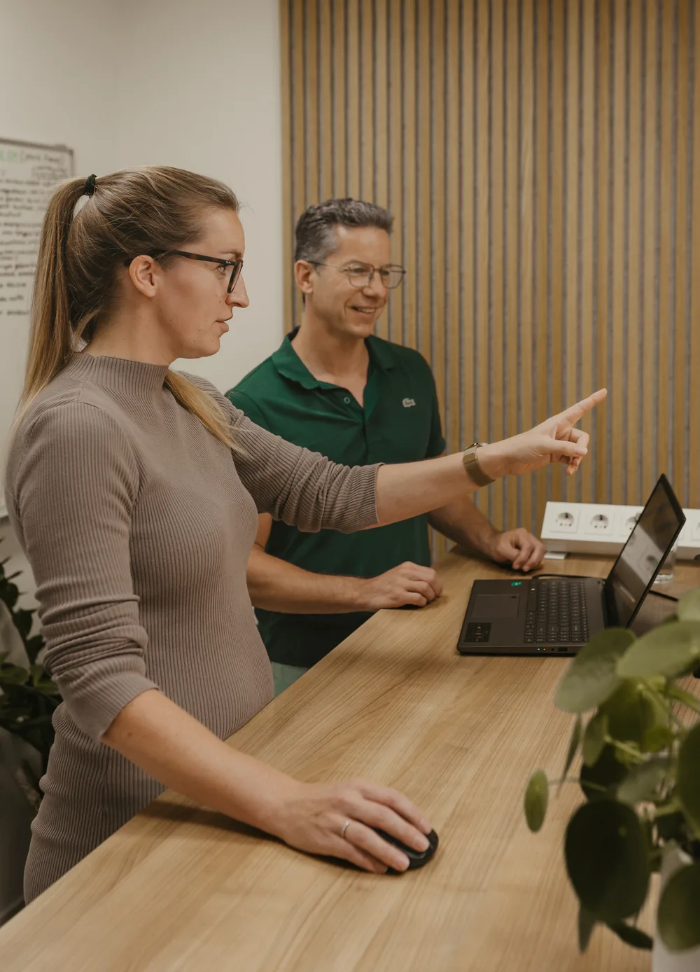 Simone overlegt met een klant bij een laptop